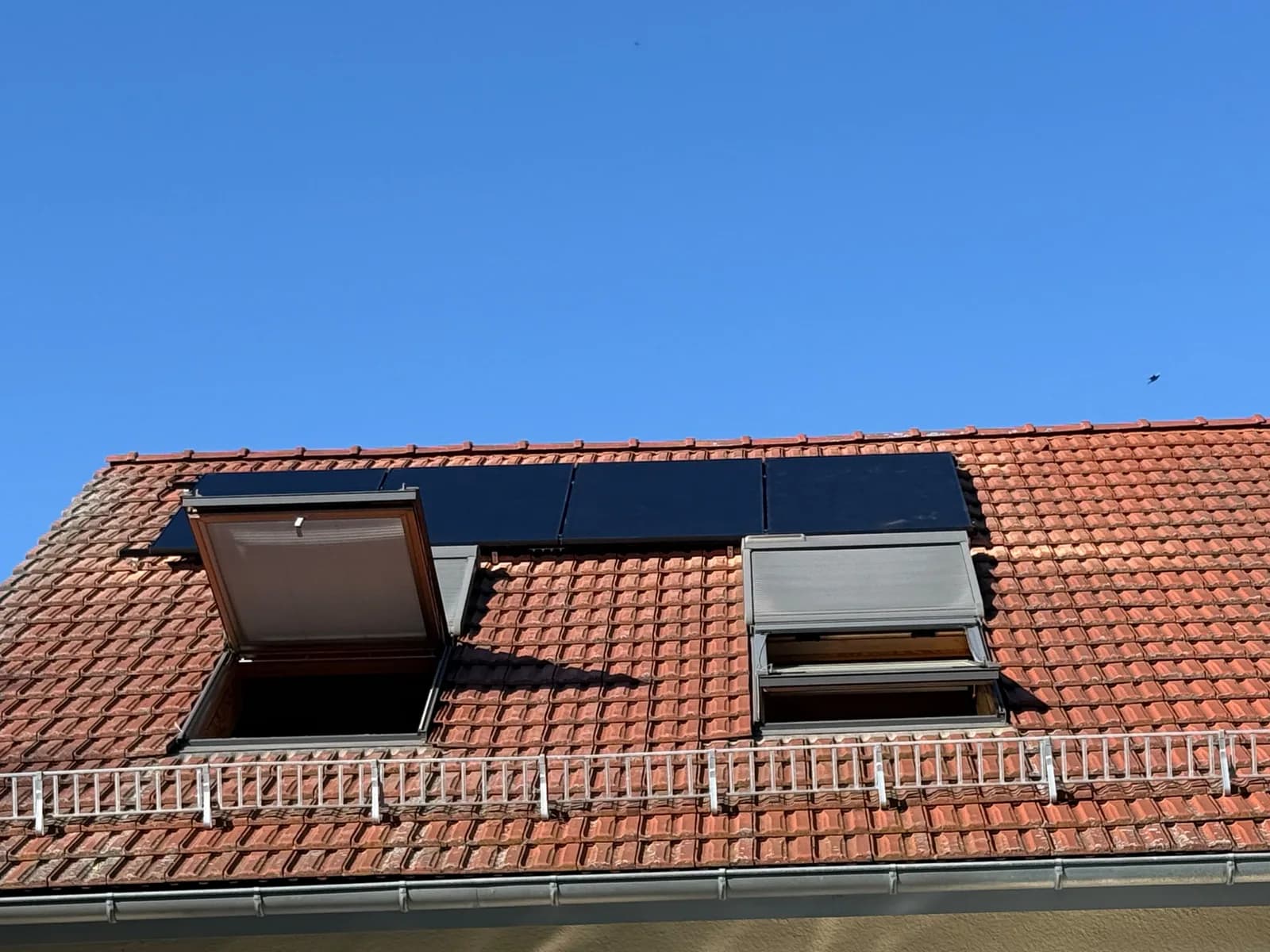 Solarmodule zwischen Dachfenstern auf einem Ziegeldach